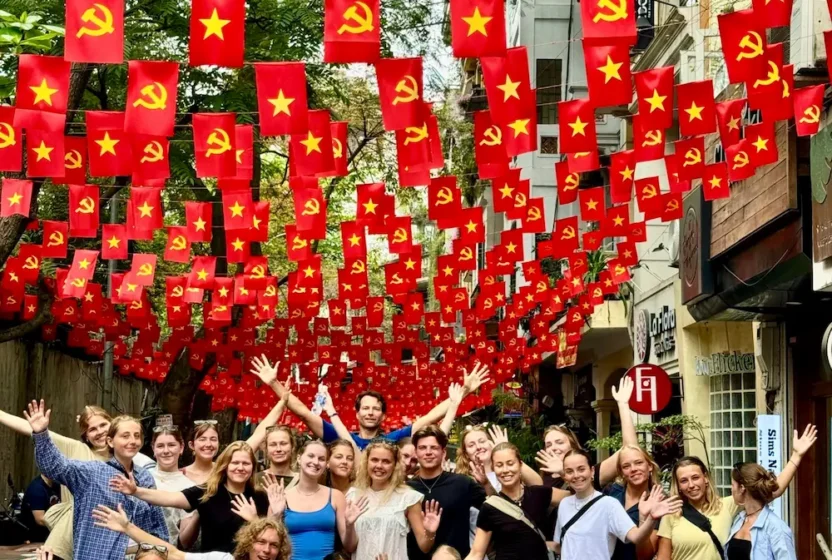 Elever poserer til et gruppebilleeder under en masse vietnamesiske flag på højskole i udlandet