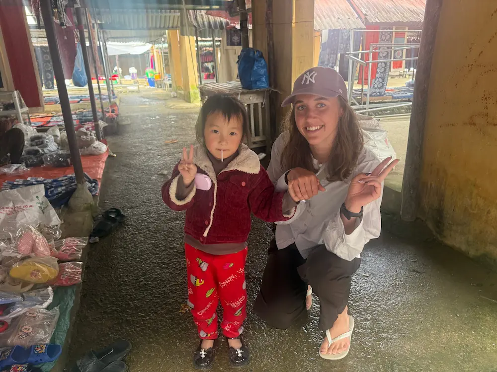 Ung kvinde står med barn i Nepal under højskole i udlandet, som deles gennem blog og rejsebreve samt anmeldelser fra tidligere elever