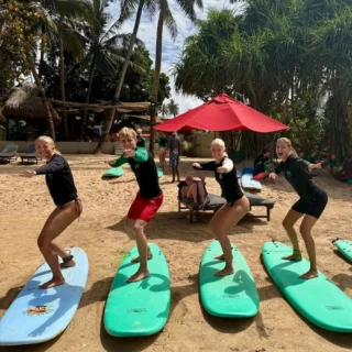 Elever trænker på surfboards på stranden på surfcamp på højskole i udlandet