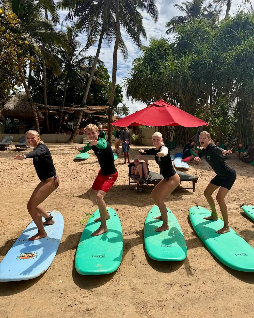 Elever trænker på surfboards på stranden på surfcamp på højskole i udlandet