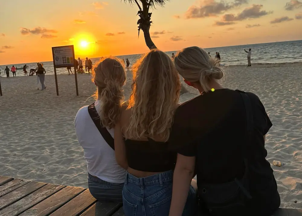 3 piger sidder og nyder udsigten til en solnedgang i Mexico på højskole i udlandet